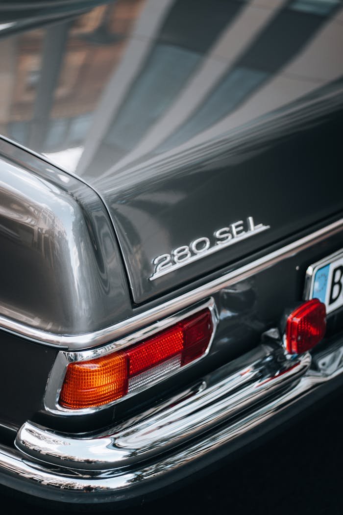 Close-up of a vintage Mercedes-Benz 280 SEL tail light and badge showcasing automotive elegance.